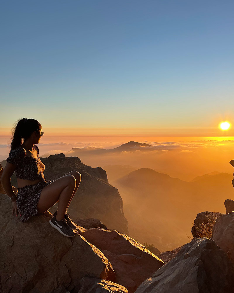 Wedding photographer watching sunset from mountain viewpoint