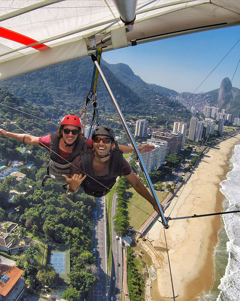 Wedding videographer and photographer hang-gliding over coastal city