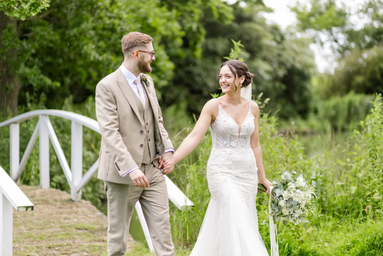 Newly Married couple walking over bridge captured by a wedding photographer