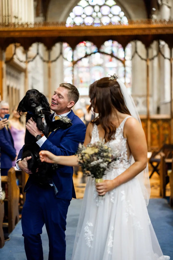 Newlyweds holding dog after getting married